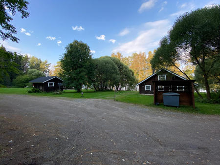 Blick auf das Ferienhaus und Nachbargrundstück vom Parkplatz aus